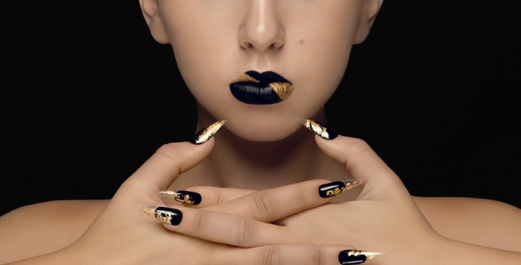 Creative beauty closeup of a fair-skinned model with black and gold lipstick and nails by Top Notch Art of Makeup