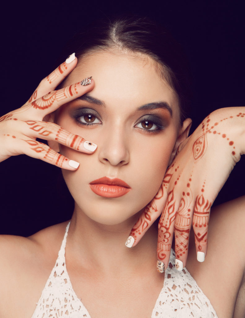 Portrait of model with earth toned makeup and henna on hands. Makeup by Top Notch Art of Makeup