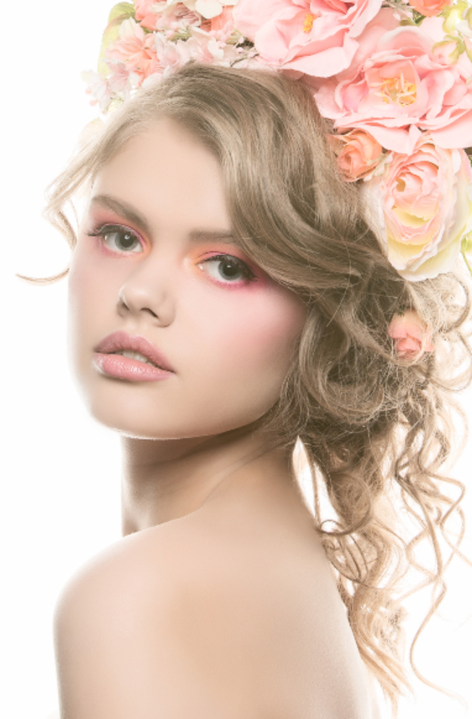 Angelic beauty makeup with soft pinks and yellow on model wearing a pink flower crown by Top Notch Art of Makeup.