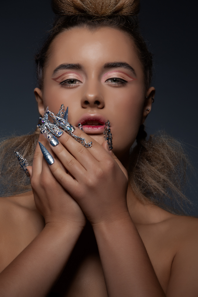 Creative peach and pink makeup on model with long blue and silver nails. Makeup by Top Notch Art of Makeup.