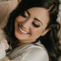 Natural glam brown and pink toned makeup on bride looking down. Bridal makeup by Top Notch Art of Makeup.